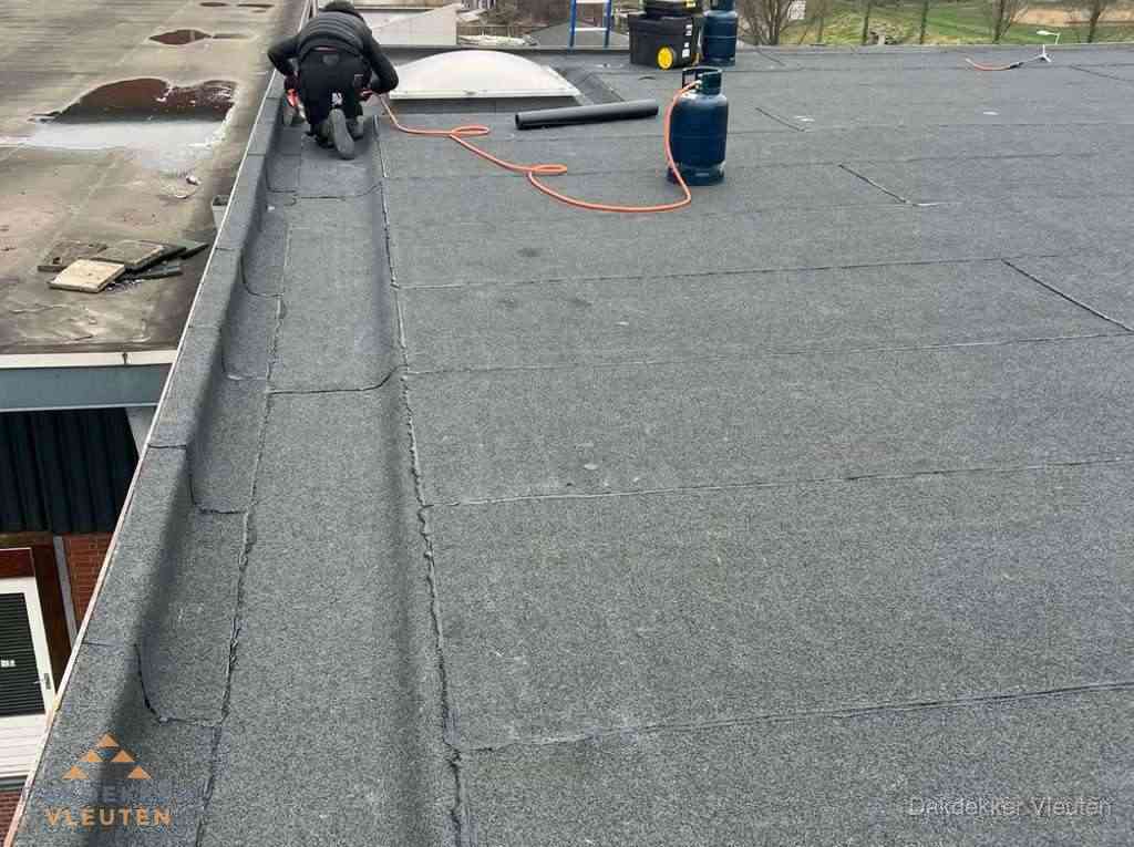 Dakdekker repareert bitumen dakbedekking op groot plat dak in Vleuten Dakdekker repareert bitumen dakbedekking op groot plat dak in Vleuten